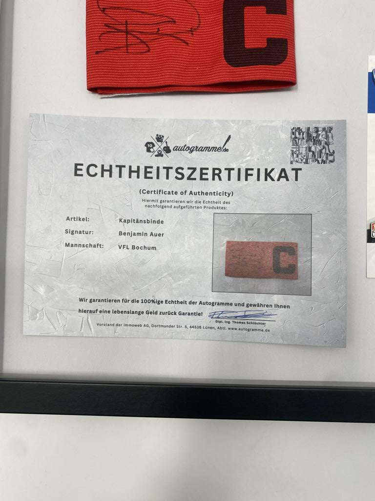 Brazalete de capitán firmado por Benjamin Auer en el marco del certificado de autenticidad del VFL Bochum.