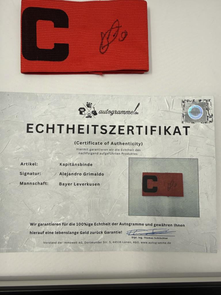 Kapitänsbinde Alejandro Grimaldo signiert im Rahmen Bayer 04 Leverkusen Autogramm