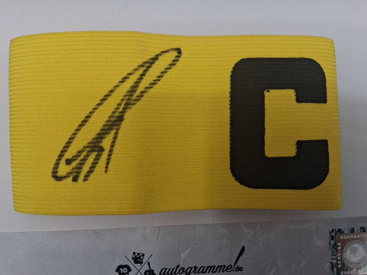 Brazalete de capitán firmado por Karim Adeyemi en un marco con certificado de autenticidad del Borussia Dortmund.