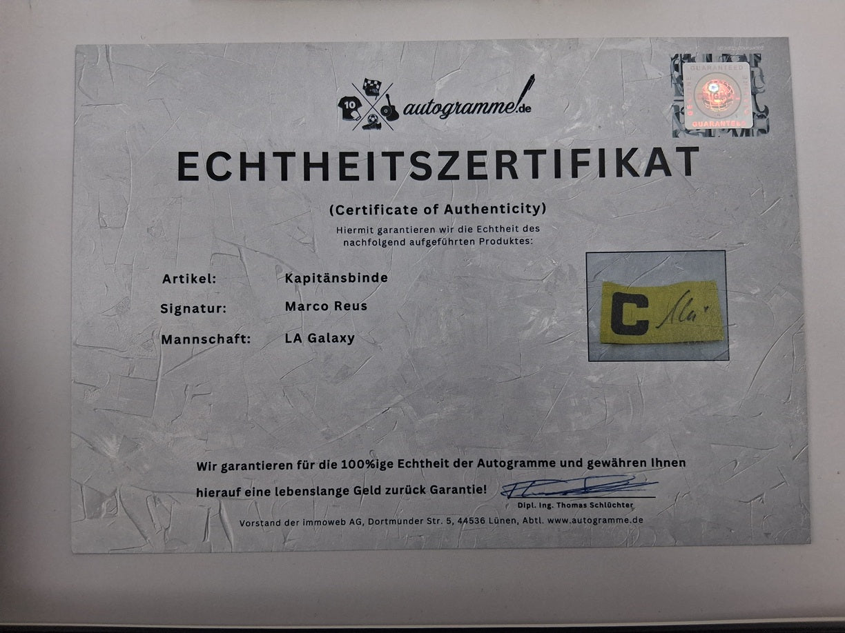 Brazalete de capitán de Marco Reus firmado en un marco con certificado de autenticidad del LA Galaxy.