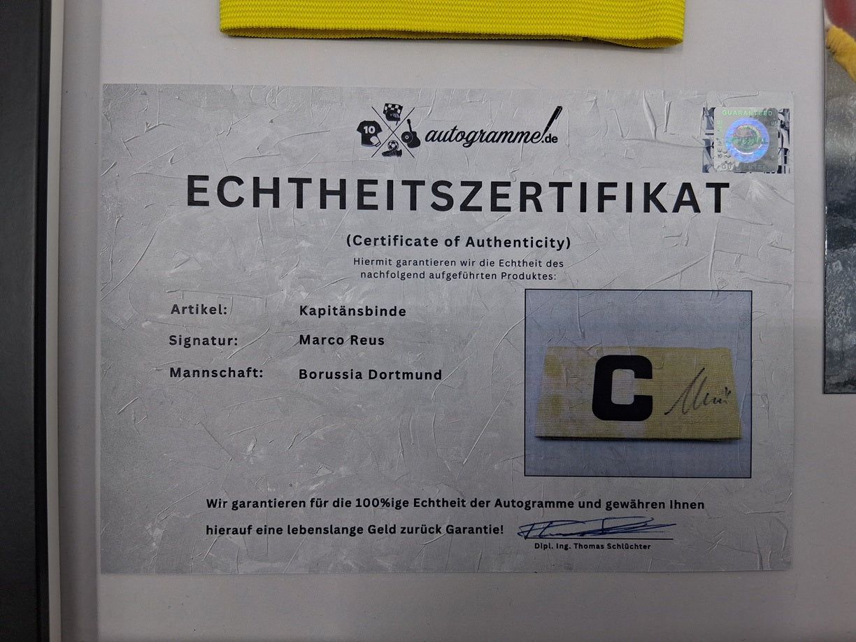 Brazalete de capitán de Marco Reus firmado en un marco con certificado de autenticidad del LA Galaxy.