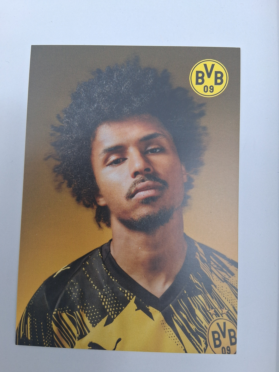 Brazalete de capitán firmado por Karim Adeyemi en un marco con certificado de autenticidad del Borussia Dortmund.