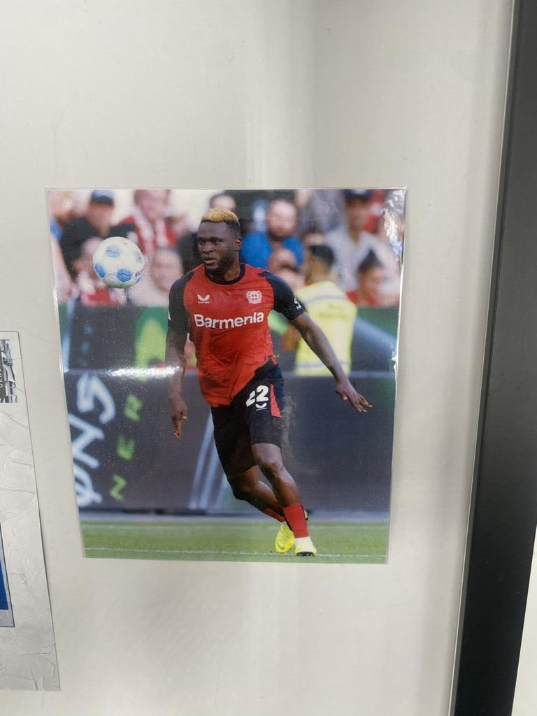 Kapitänsbinde Victor Boniface signiert im Rahmen Bayer Leverkusen Autogramm