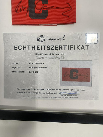 Kapitänsbinde Wolfgang Overath signiert im Rahmen 1. FC Köln Autogramm