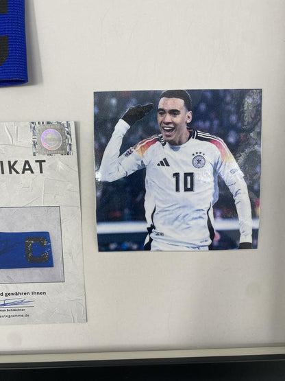 Captain's armband signed by Jamal Musiala in a Bayern Munich autograph frame