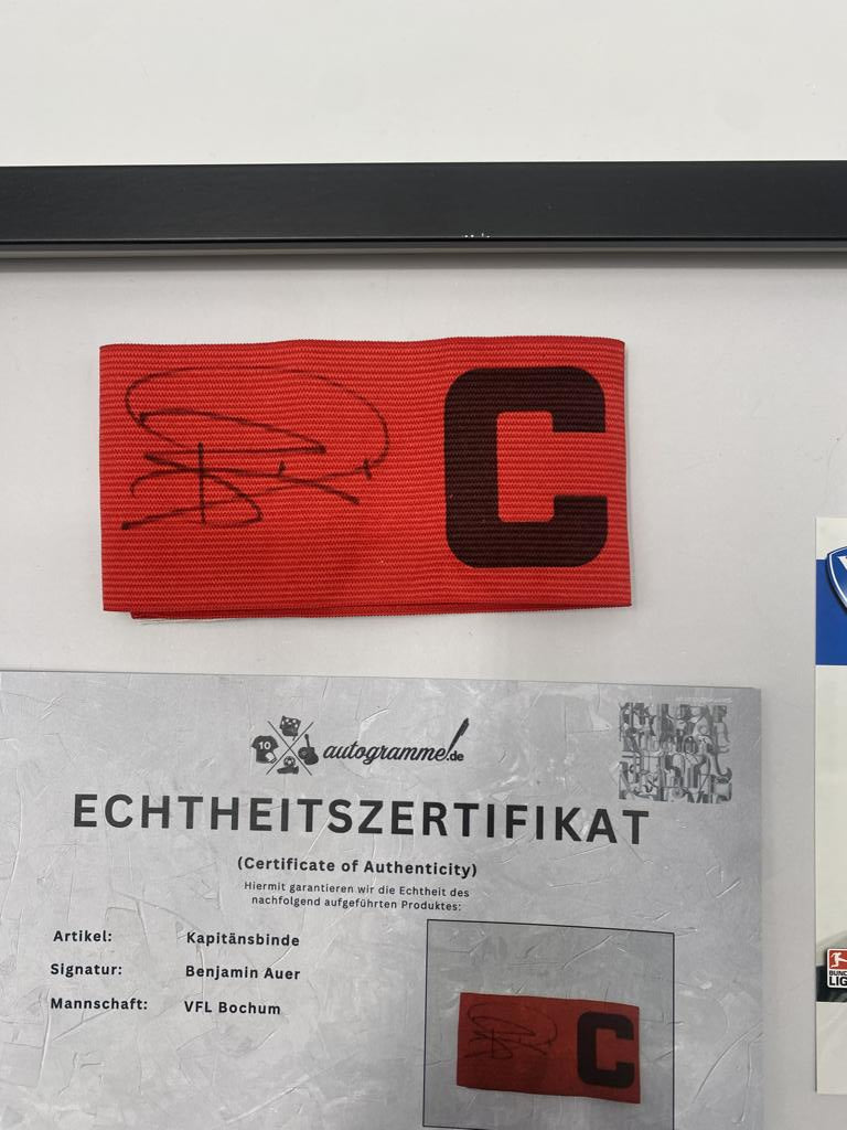 Brazalete de capitán firmado por Benjamin Auer en el marco del certificado de autenticidad del VFL Bochum.