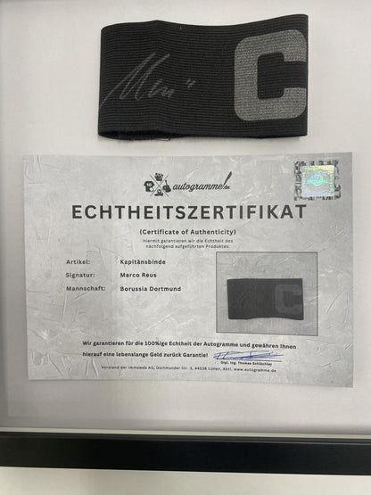 Brazalete de capitán firmado por Marco Reus en un marco con certificado de autenticidad del Borussia Dortmund.
