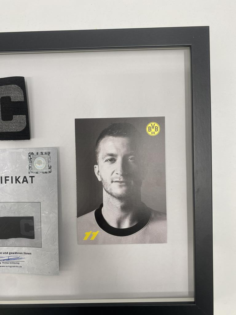 Brazalete de capitán firmado por Marco Reus en un marco con certificado de autenticidad del Borussia Dortmund.