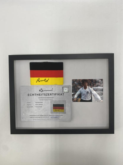 Brazalete de capitán firmado por Rainer Bonhof, enmarcado y con certificado de autenticidad de Alemania.