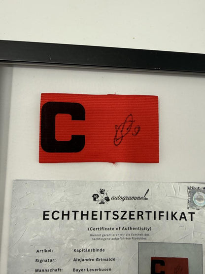 Kapitänsbinde Alejandro Grimaldo signiert im Rahmen Bayer 04 Leverkusen Autogramm