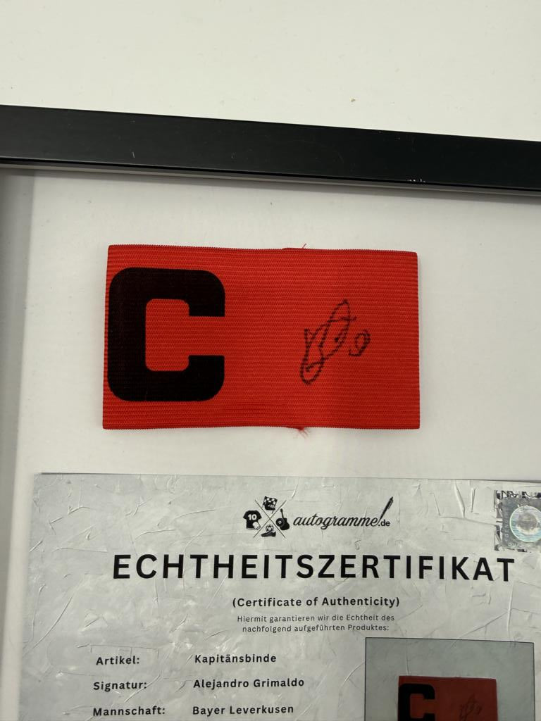 Kapitänsbinde Alejandro Grimaldo signiert im Rahmen Bayer 04 Leverkusen Autogramm