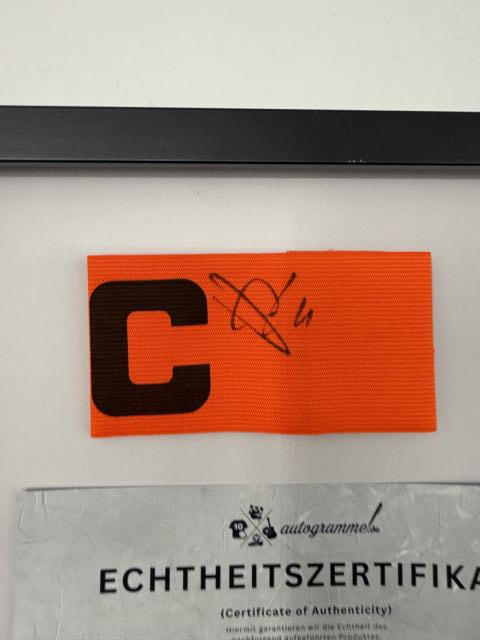 Kapitänsbinde Jeanuël Belocian signiert im Rahmen Bayer Leverkusen Autogramm