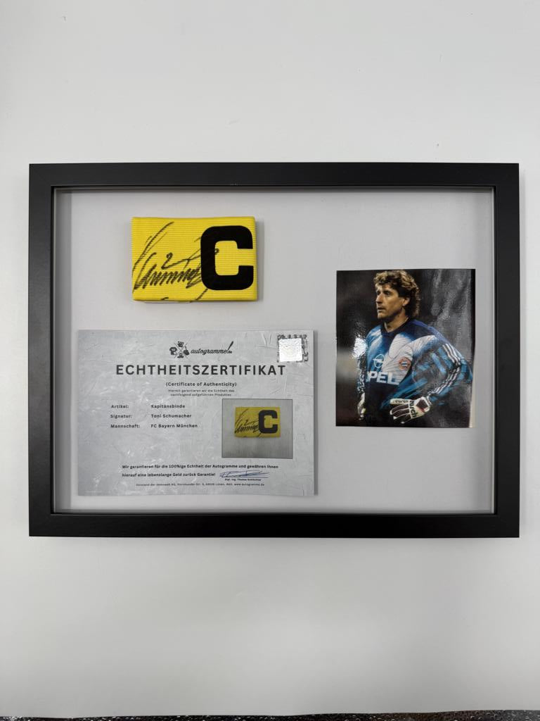 Kapitänsbinde Toni Schumacher signiert im Rahmen FC Bayern München Fußball Autogramm