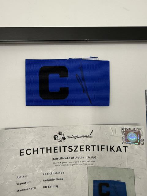 Kapitänsbinde Antonio Nusa signiert im Rahmen RB Leipzig Autogramm