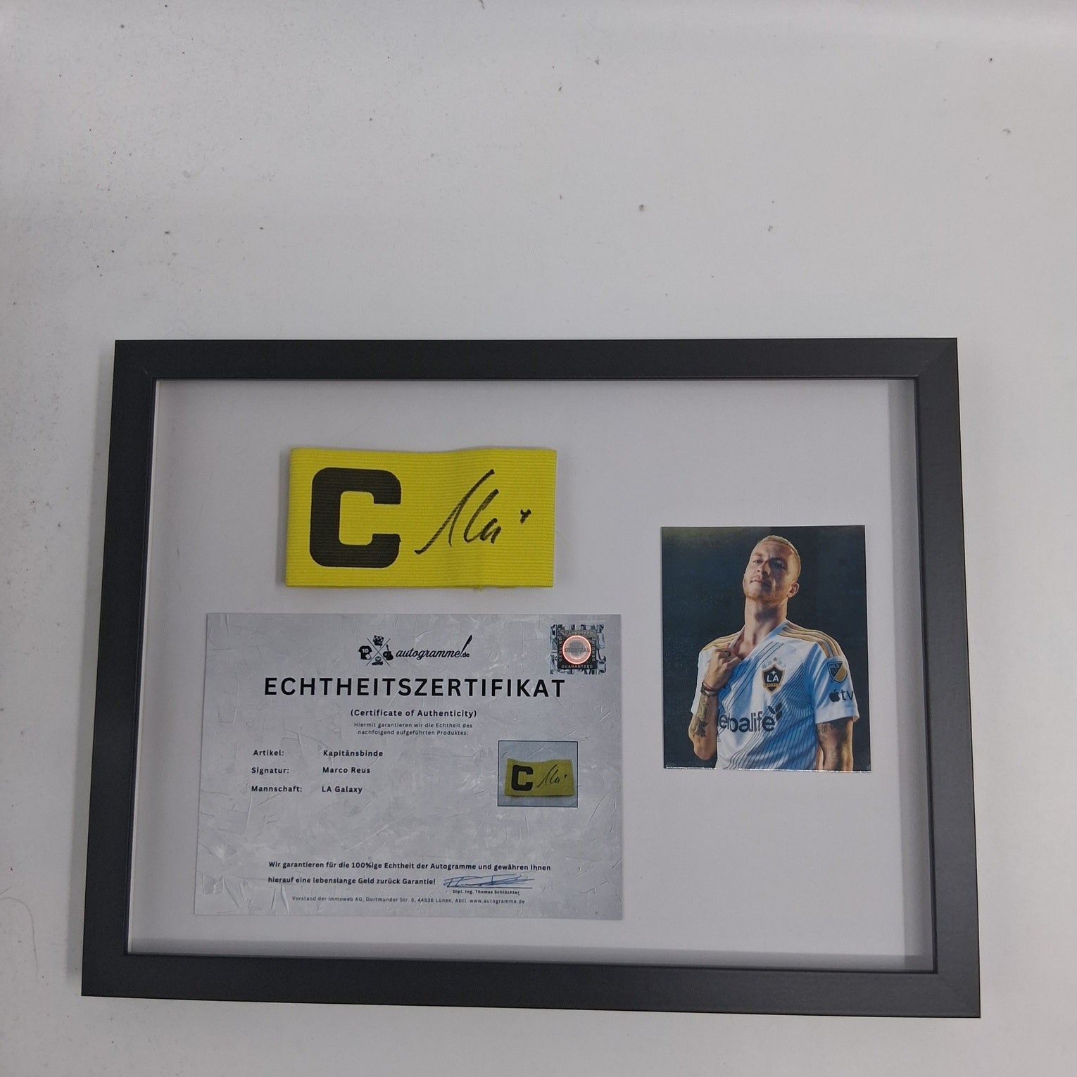 Brazalete de capitán de Marco Reus firmado en un marco con certificado de autenticidad del LA Galaxy.
