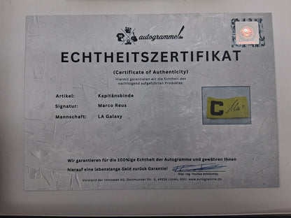 Brazalete de capitán de Marco Reus firmado en un marco con certificado de autenticidad del LA Galaxy.
