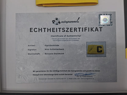 Brazalete de capitán firmado por Nico Schlotterbeck en un marco COA de Alemania