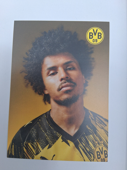 Brazalete de capitán firmado por Karim Adeyemi en un marco con certificado de autenticidad del Borussia Dortmund.