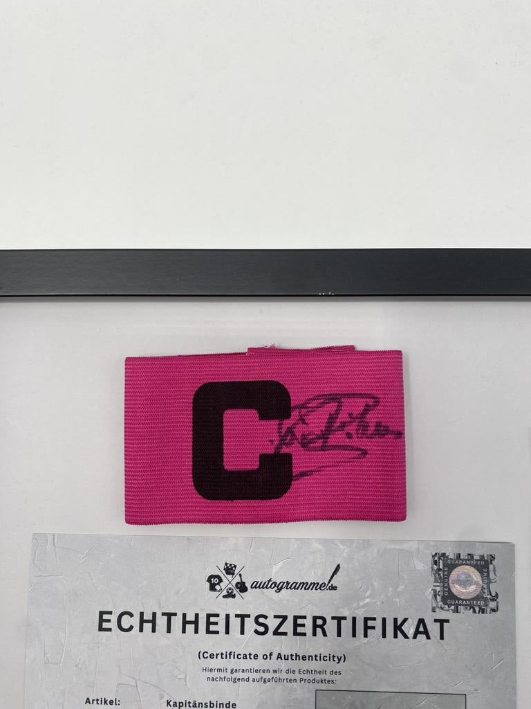 Brazalete de capitán firmado por Paul Breitner en un marco de autógrafos del Bayern de Múnich.